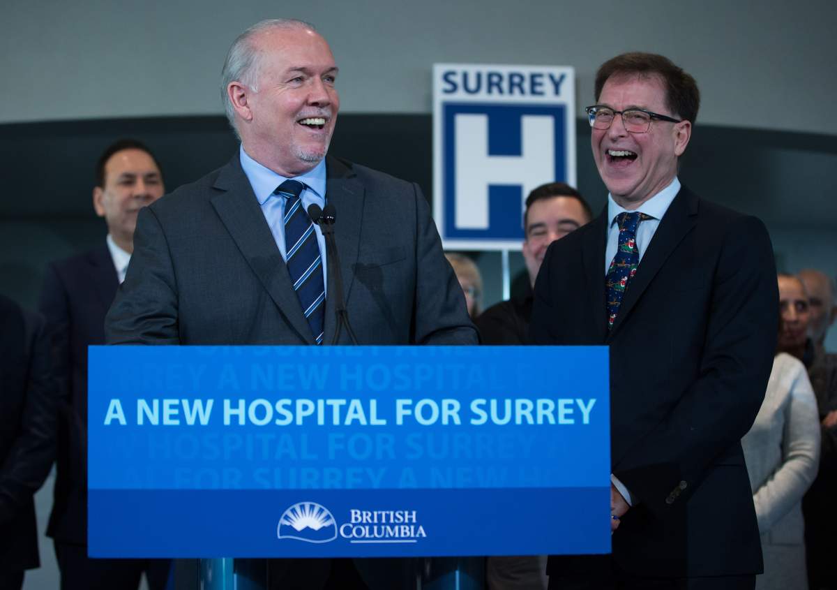 British Columbia Premier John Horgan, left, and Health Minister Adrian Dix share a laugh after announcing a new hospital would be built in Surrey, B.C., on Monday December 9, 2019. 