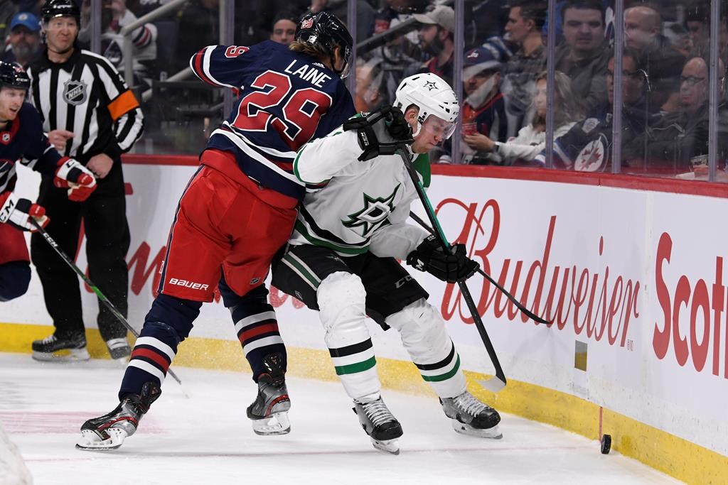 Winnipeg Jets' Patrik Laine (29) and Dallas Stars' Radek Faksa (12) battle for the puck during second period NHL action in Winnipeg on Tuesday, Dec. 3, 2019.
