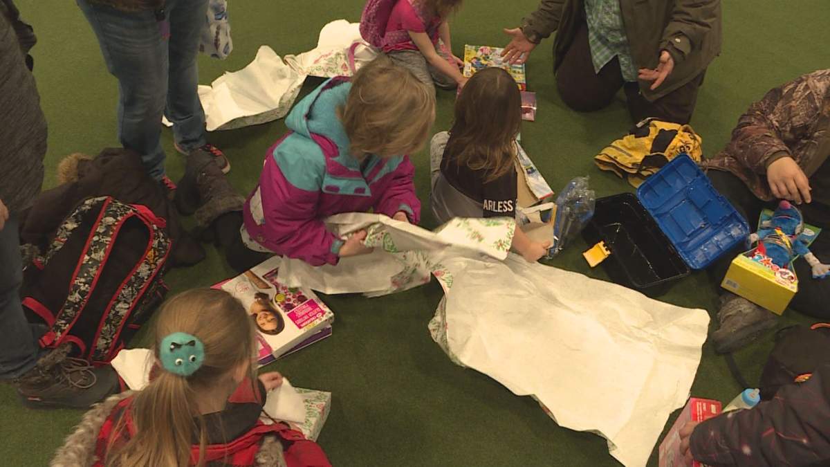 Children open presents at the Calgary Firefighters Toy Association party.