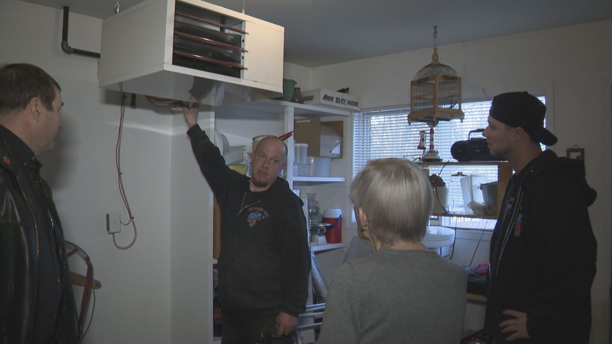Crews give Adrienne Gnam some details on her new furnace. 