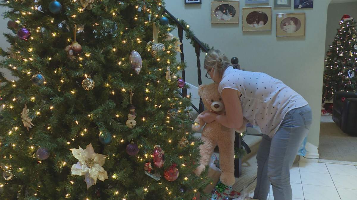 Alana Edwards places a gift for a senior near her home Christmas tree, Dec 14, 2019.