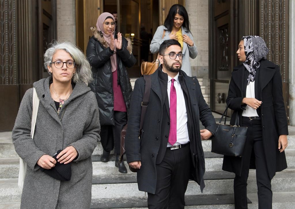 Members of the National Council of Muslims Mustafa Farooq, centre, and Bochra Manai, left, alongside supporters leave the Quebec Court of Appeal in Montreal, Tuesday, Nov. 26, 2019, where they are challenging Quebec's Bill 21.