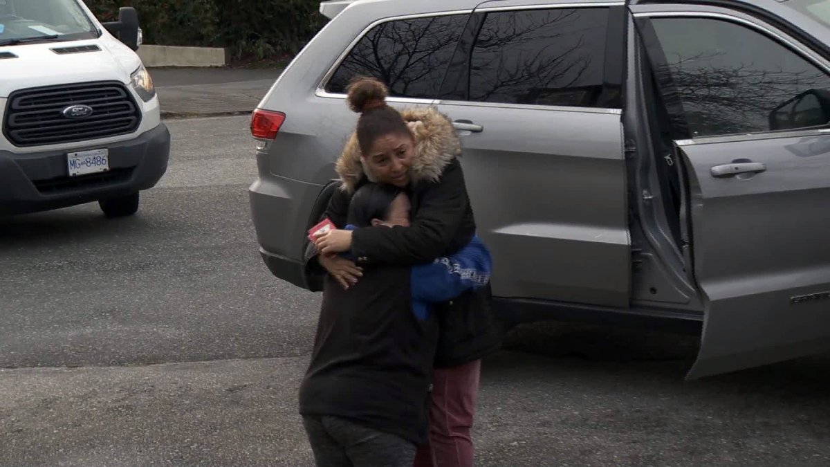 Milagro Guillen hugs a neighbour a day after her son was seriously hurt in a hit-and-run in Burnaby. 
