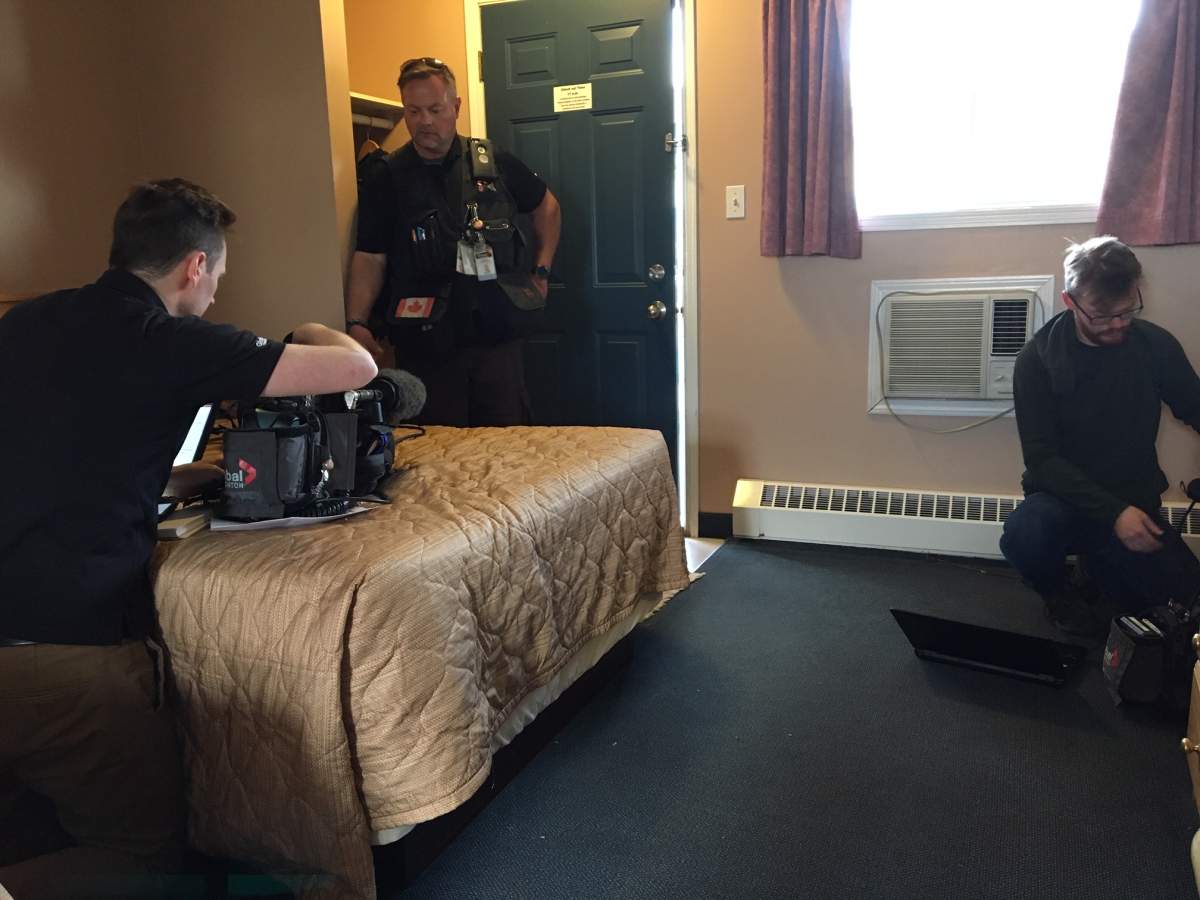 Reporter Tom Vernon (left), cameraman Dean Twzardzik (middle) and cameraman Les Knight (right) work in a motel room in High Level.