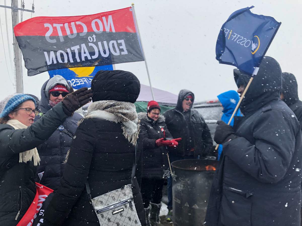 Striking London teachers gather around a fire during a demonstration outside Banting Secondary School on Wednesday.