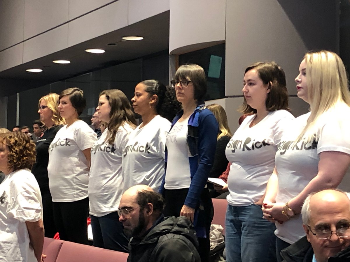 A group of protesters stand at council on Wednesday calling for Councillor Rick Chiarelli to resign over allegations he faces of misconduct.