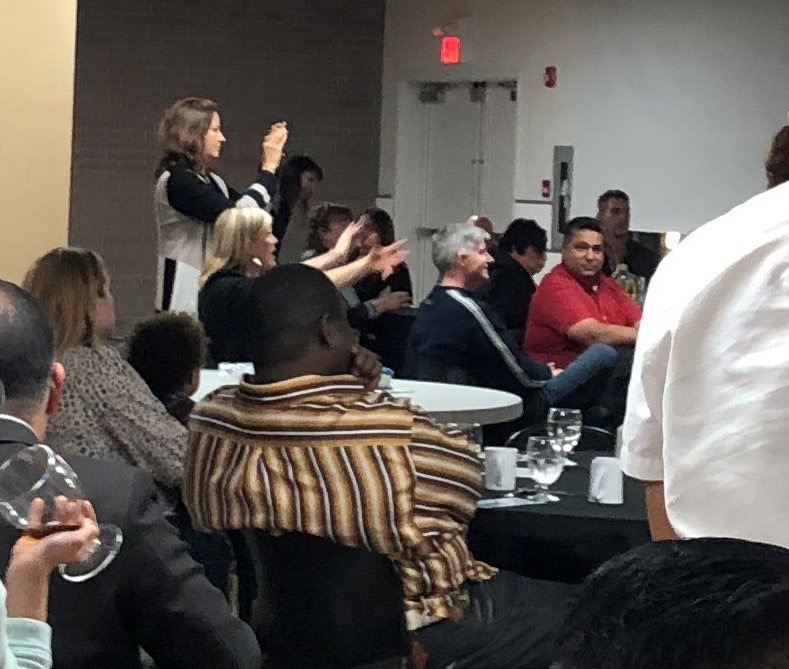 A picture taken at a Faith and Freedom Celebration in November 2018. The man in the foreground wearing a striped shirt was identified as Ray Goldenchild, but was actually Ron Hailey.