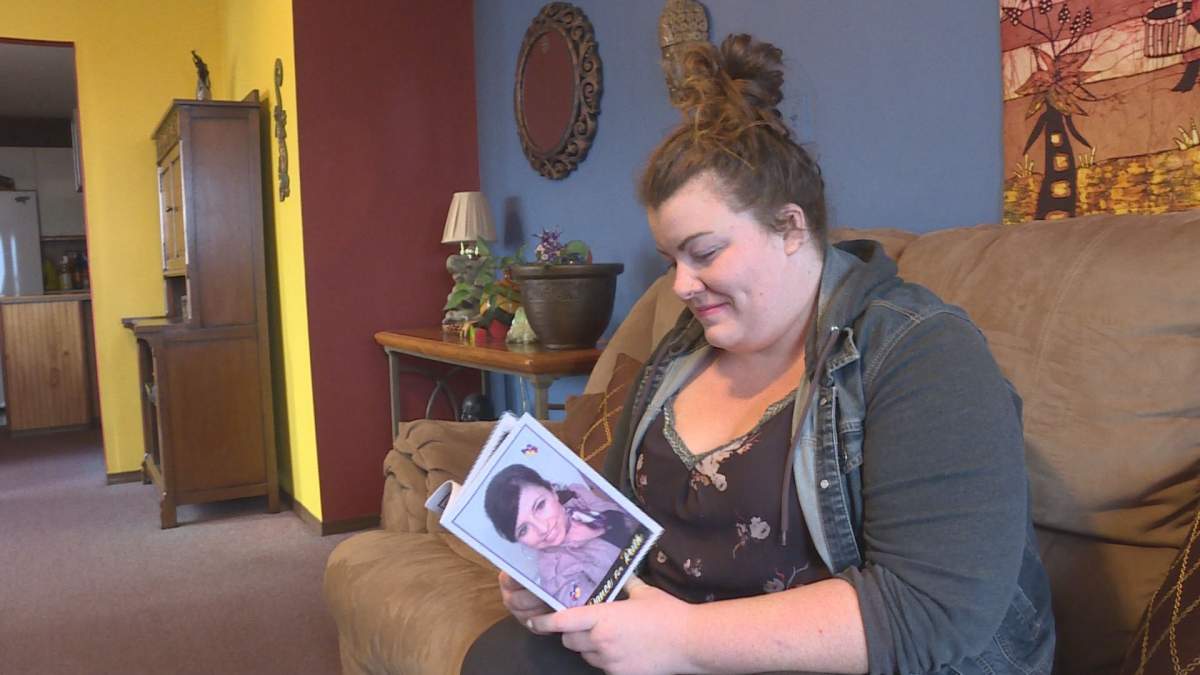 Petition organizer Jessica Tabe looks at a memorial program for her grandmother-in-law Ruth Blencoe who was killed in a crash on Highway 97 A in February.