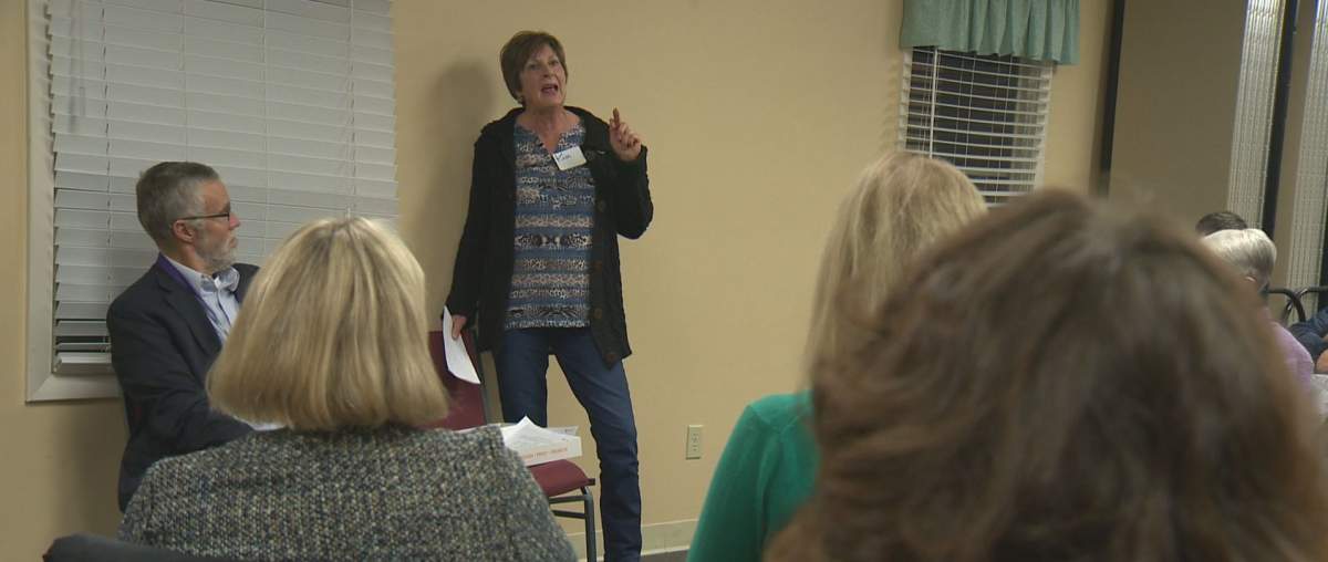 Kim Watson speaking at the Better Angels health-care debate. Chris Watson (seated) acted as moderator.