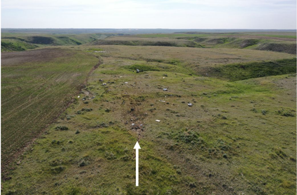 Plane crash site, looking west. The white arrow indicates the direction of flight and the initial ground impact.