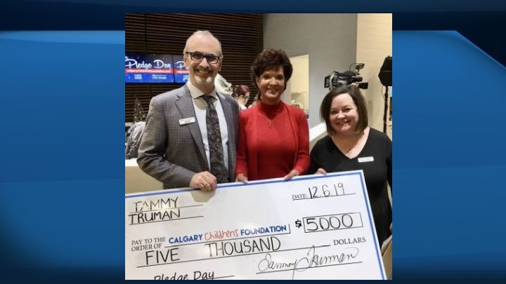 Calgary Children's Foundation chair John Vos and administrator Betty Jo Kaiser accept a donation from Tammy Truman, owner of Truman Insurance.
