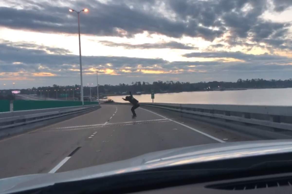 A man is shown skateboarding on an interstate highway bridge in Louisiana in this image from video posted on Facebook on Dec. 22, 2019.