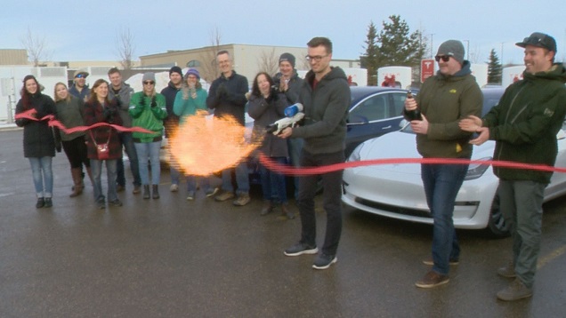 Tesla Owners of Saskatchewan melt the ribbon at Regina's first Supercharger station using an flamethrower designed by Elon Musk.