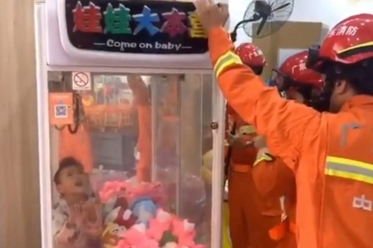 Firefighters work to free a young boy from a claw machine at a mall in Guangdong, southern China, on Dec. 1, 2019.