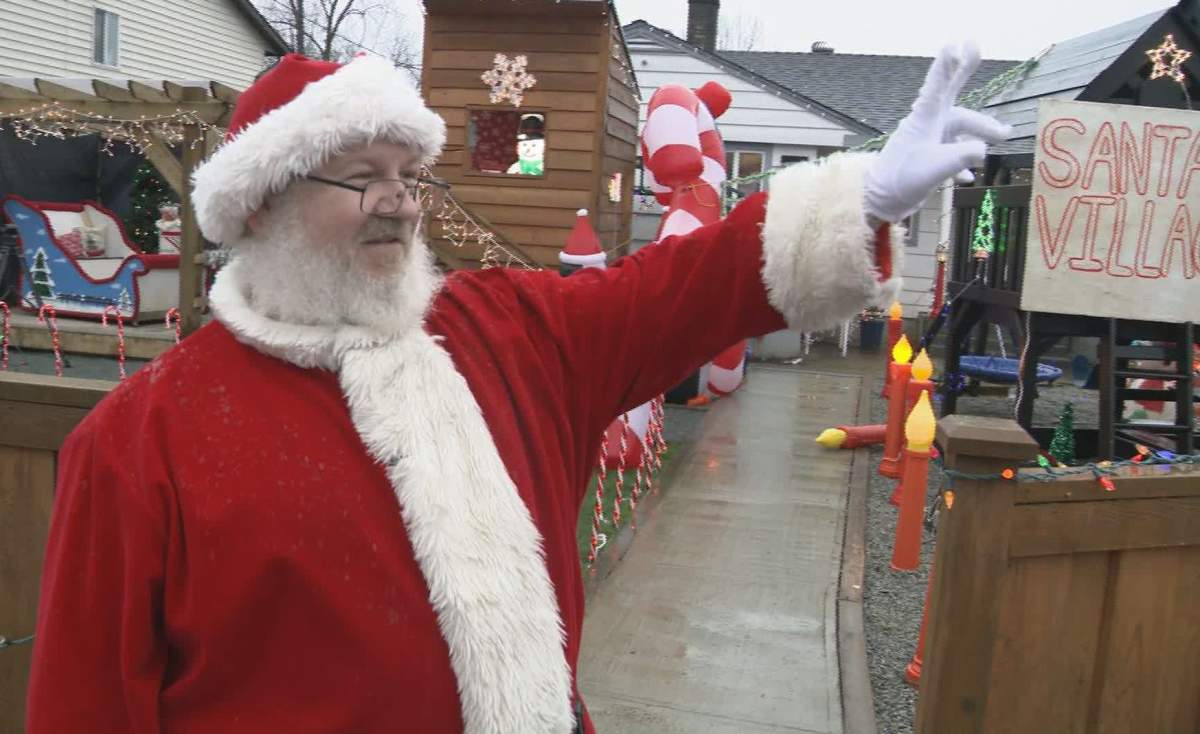 Don Taylor waves outside his Maple Ridge, B.C., home where he set up a "Santa's Village" on Dec. 19, 2019. The City of Maple Ridge has ordered him to shut the village down, saying it's in violation of city bylaws.