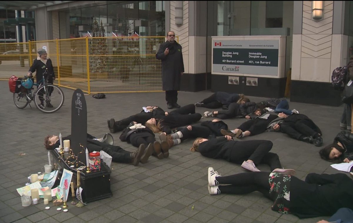 Vancouver teen climate activists lie in front of an Environment Canada building in downtown Vancouver while staging a "funeral for our future" over inaction on climate change on Dec. 14, 2019.