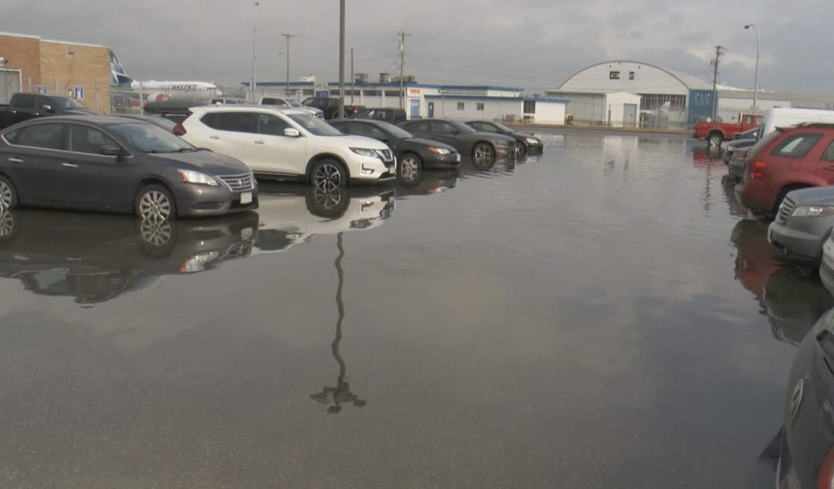 Parked cars sit in pooled water at Vancouver International Airport's south terminal on Dec. 14, 2019.