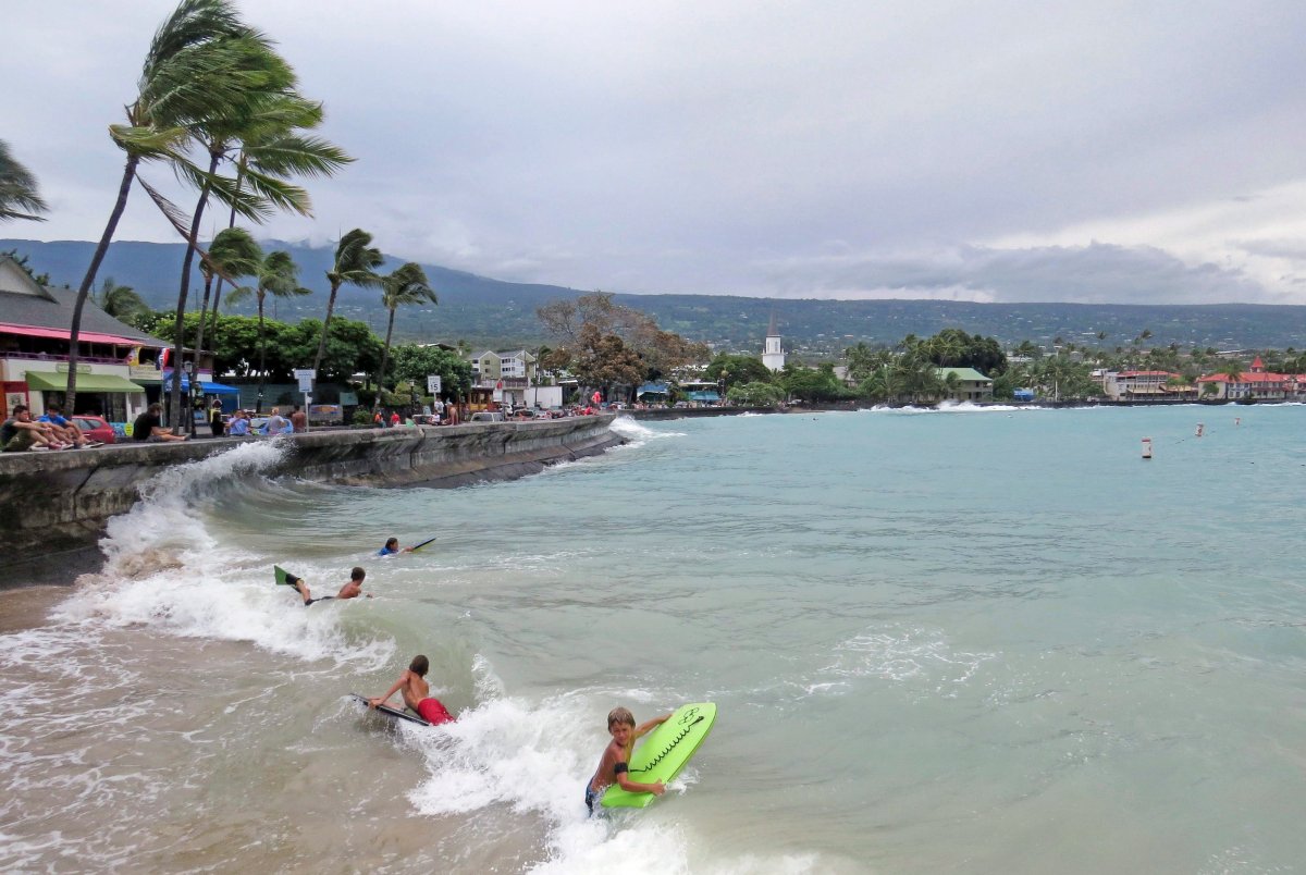 Young board surfers ride storm-driven waves under the seawall on Ali'i Drive in Kailua-Kona, Hawaii, Friday, Aug. 8, 2014.