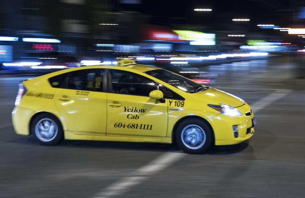 A "Yellow Cab" taxi drives along Burrard Street at Broadway Avenue, Vancouver, B.C., October 24, 2014. 