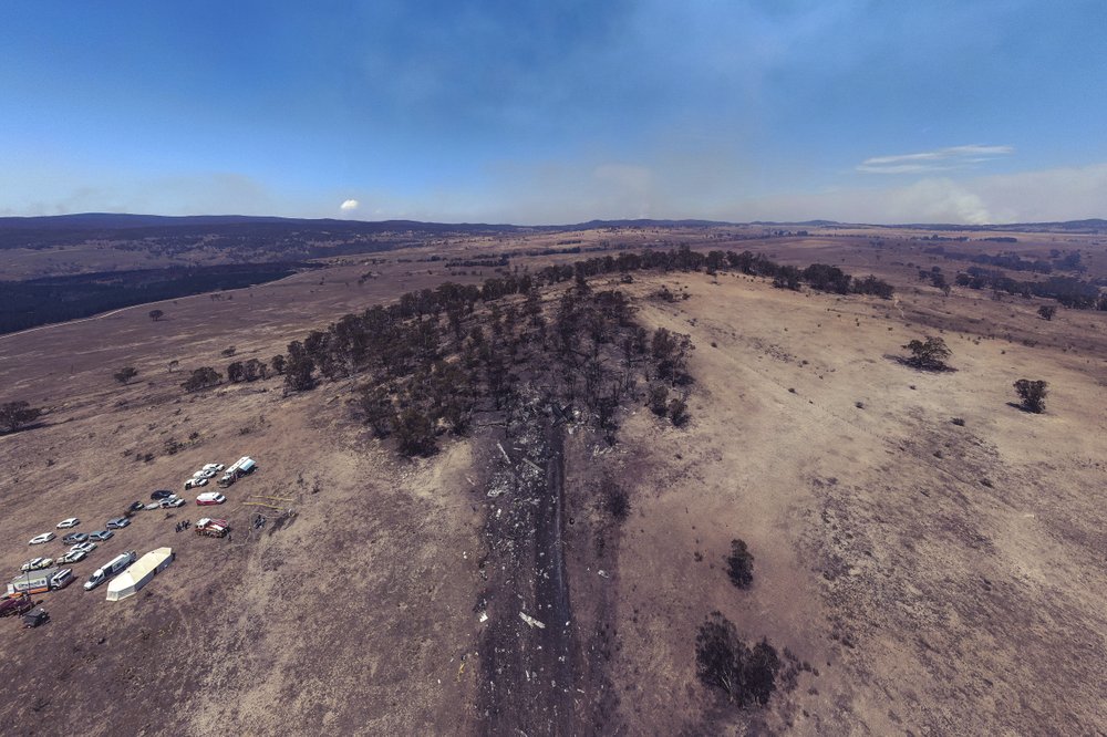 This Friday, Jan. 24, 2020, aerial photo provided by the New South Wales Police, shows wreckage, center, is strewn at the crash site of a firefighting air tanker near Numeralla, south west of Sydney. Three crew from the U.S. were killed when their C-130 Hercules tanker crashed while fighting wildfires in Australia, their employer, Canada-based Coulson Aviation, said in a statement. 
