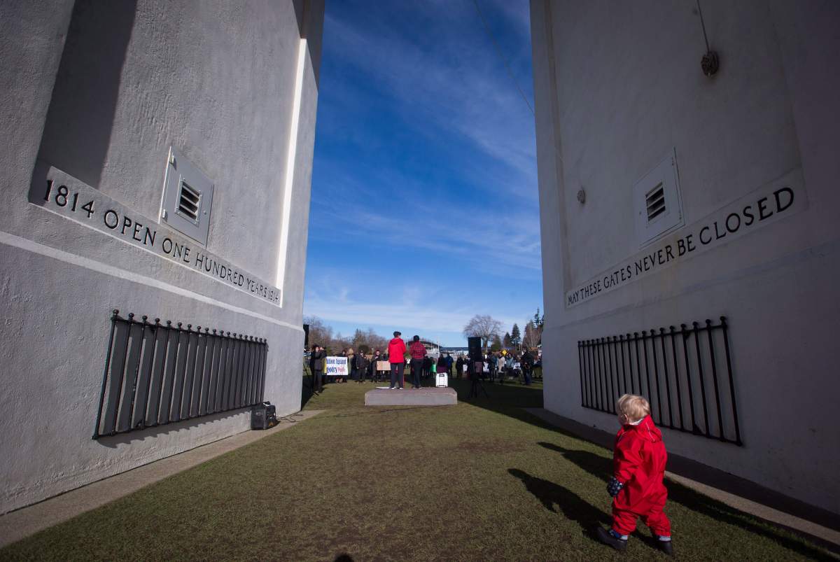 A young boy walks under the Peace Arch during a ‘No Wall, No Ban’ rally at the Peace Arch-Douglas border crossing between Canada and the United States, in Surrey, B.C., on Feb. 12, 2017.