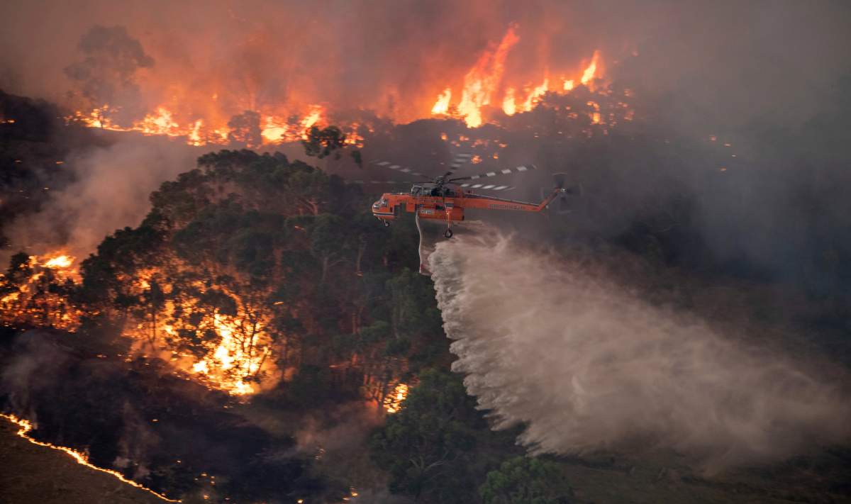 In this Dec. 30, 2019 photo provided by State Government of Victoria, a helicopter tackles a wildfire in East Gippsland, Victoria state, Australia.