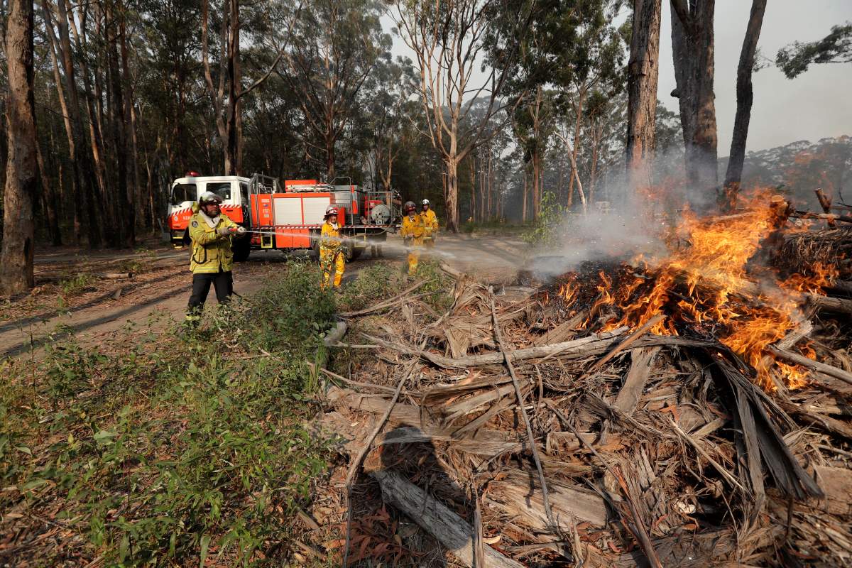 Firefighters battles a fire near Bendalong, Australia, Friday, Jan. 3, 2020.