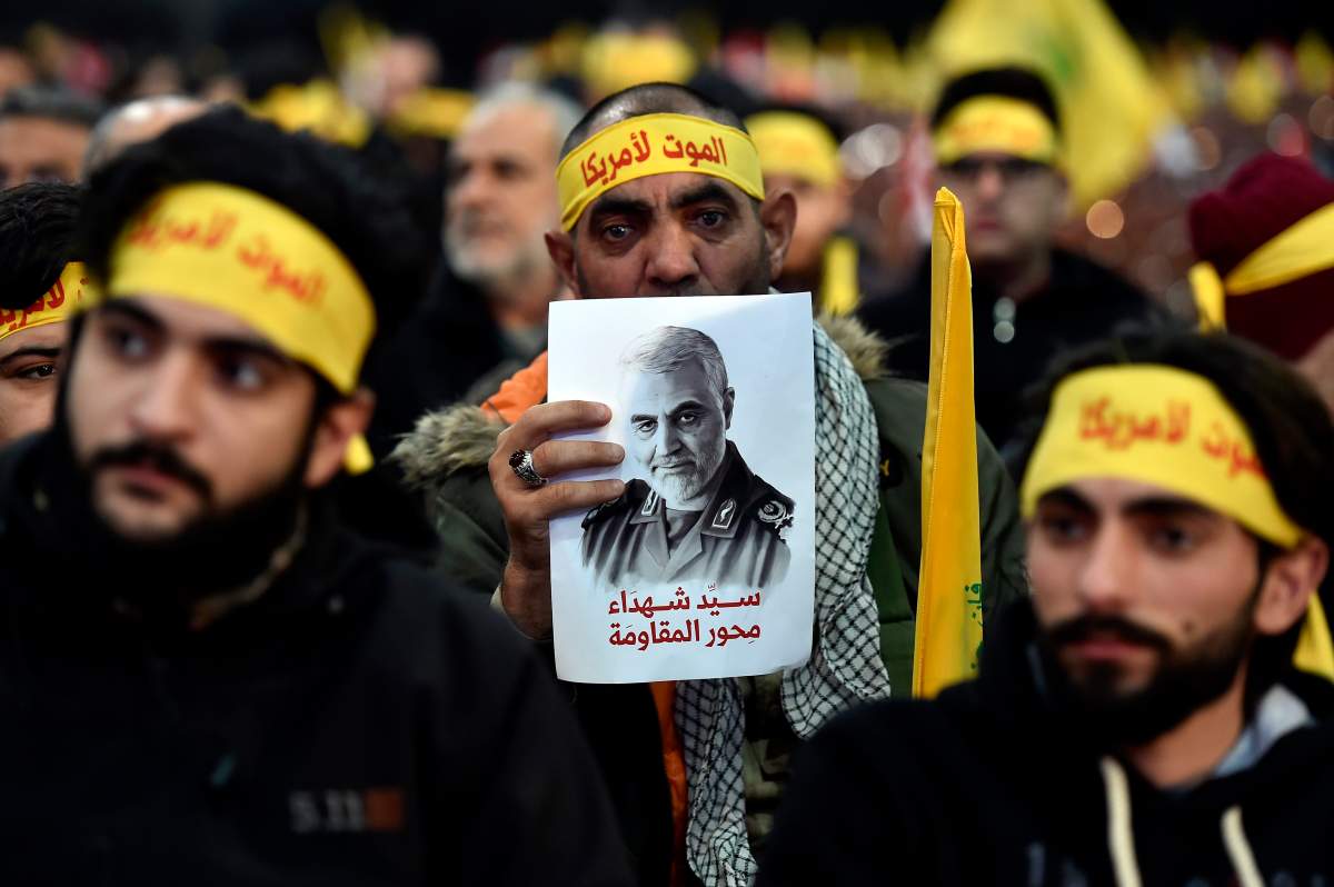 A supporter of Hezbollah wears a headband that reads, ‘death to America,’ and carries a picture of slain Qassem Soleimani in the southern suburb of Beirut, Lebanon, Jan. 5, 2020.