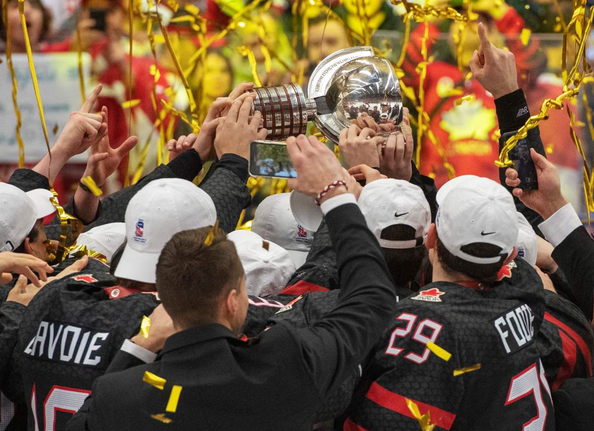 FILE -- Team Canada players reach for the trophy after defeating Russia 4-3 in the gold medal game at the World Junior Hockey Championships, Sunday, January 5, 2020 in Ostrava, Czech Republic. 