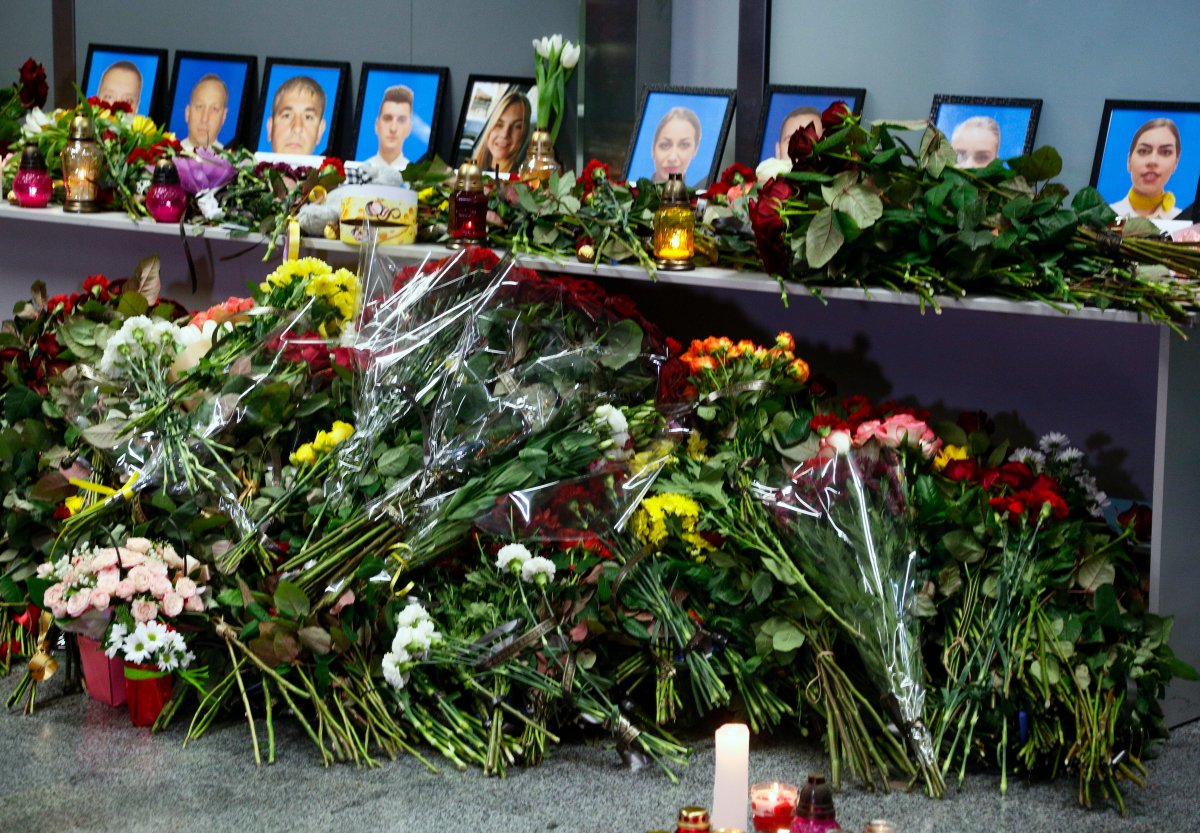 Flowers and candles are placed in front of portraits of the flight crew members of the Ukrainian 737-800 plane that crashed on the outskirts of Tehran, at a memorial inside Borispil international airport outside Kyiv, Ukraine, Wednesday, Jan. 8, 2020. 