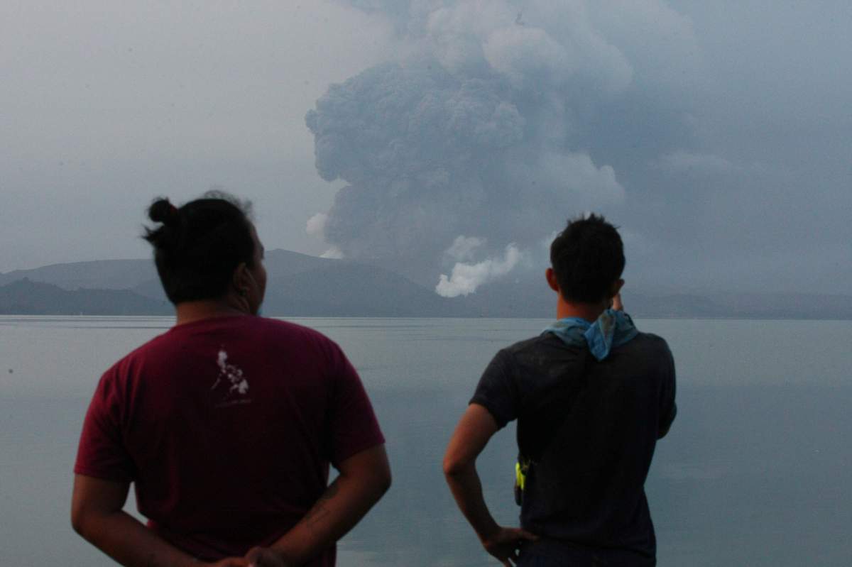 Residents watch Taal volcano spew ash from a look out in Talisay, Batangas province, southern Philippines on Monday, Jan. 13, 2020.