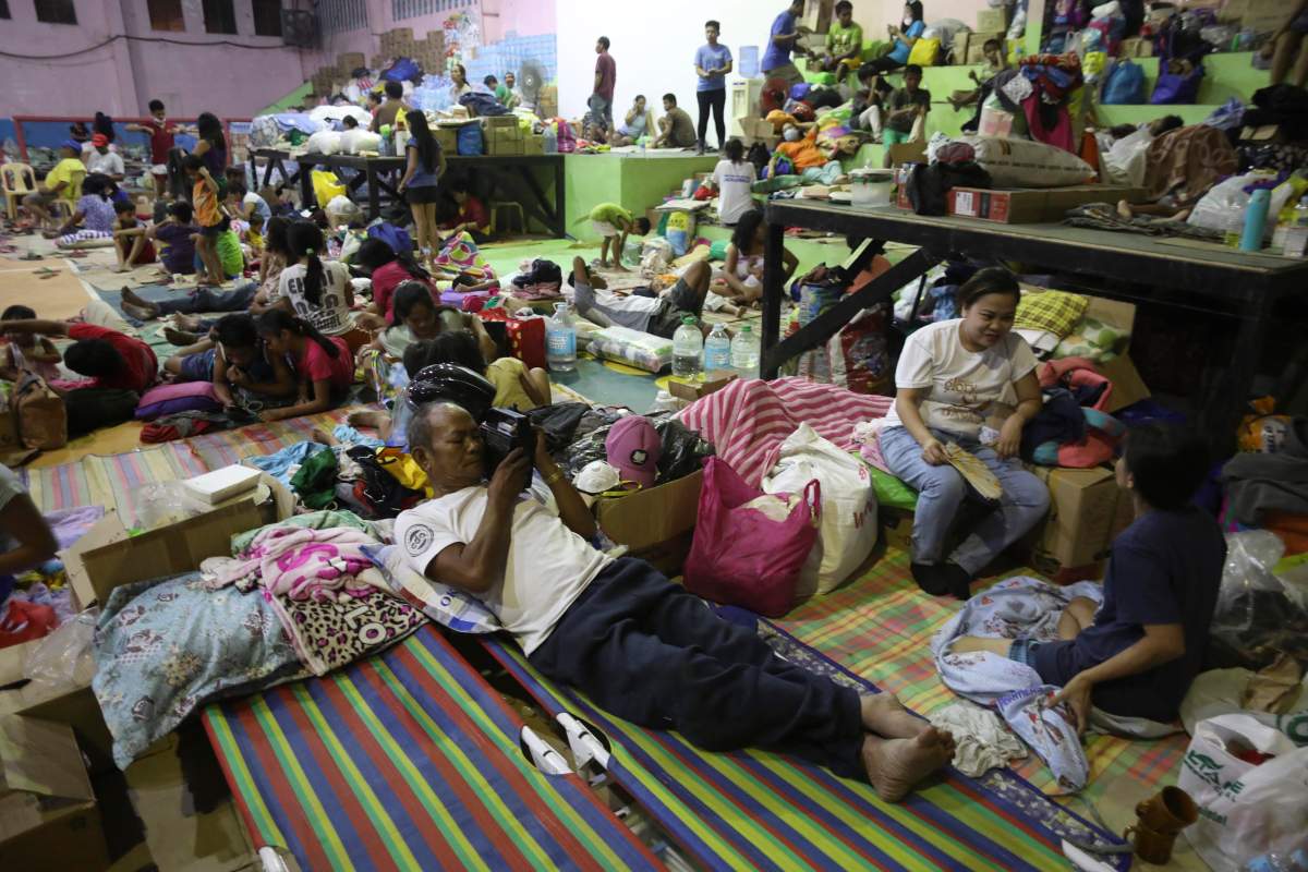 Sylvestre Barba (C) listens to a radio inside an evacuation center for citizens affected by the eruption of Taal Volcano in Santo Tomas, Batangas, Philippines, 15 January 2020.