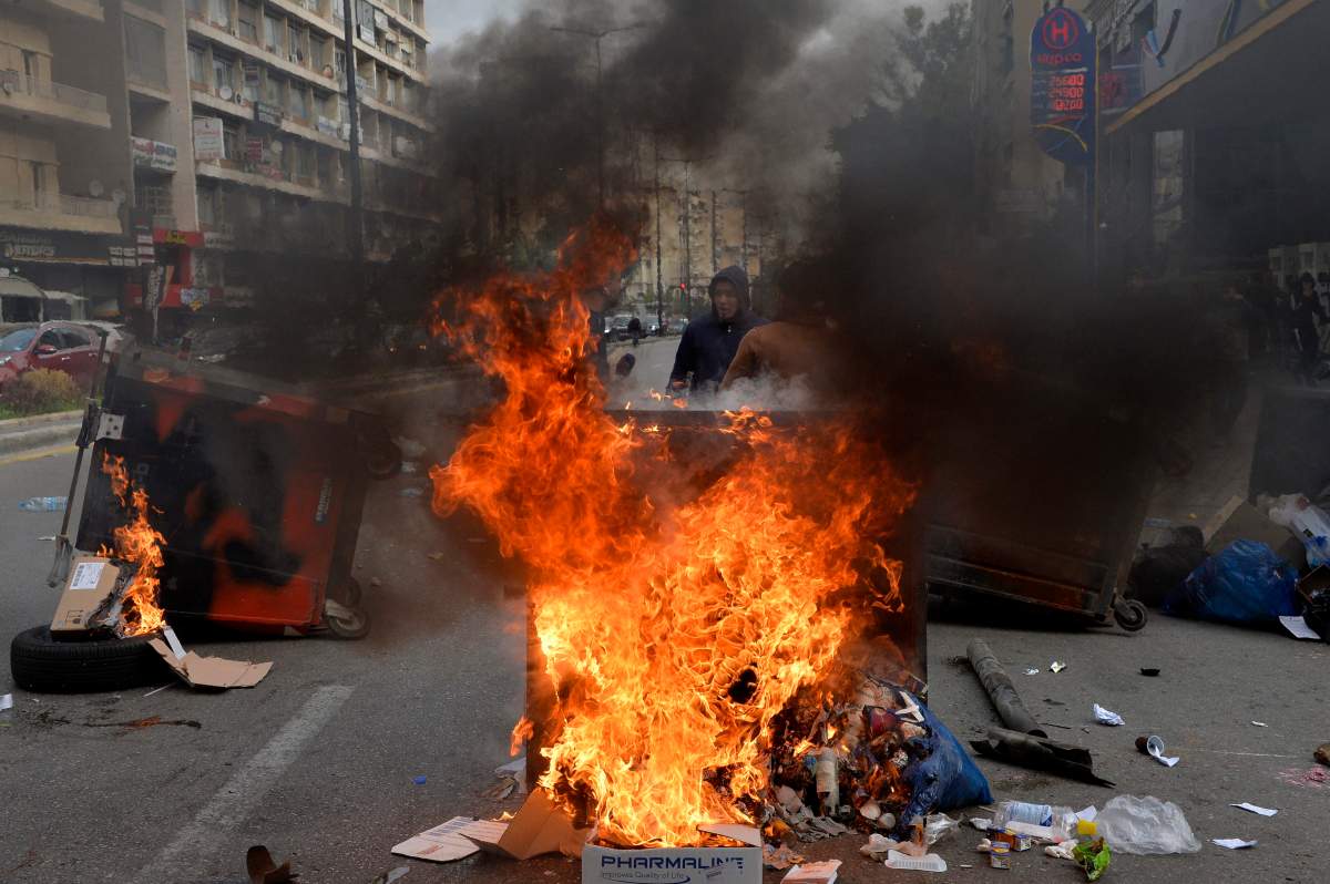 Anti-government protesters burn dumpsters as they block the main road during a protest near a barrack where 59 protesters are detained following overnight clashes near Lebanese Central Bank in Beirut, Lebanon, 15 January 2020. According to media reports, several protesters were injured and 59 protesters detained during the clash with riot police on 14 January, and more of the ATM and the windows of banks in Hamra Main Street are being smashed.