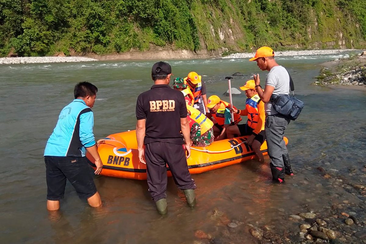 In this photo released by the Disaster Mitigation Agency of Bengkulu Province's Kaur District, a rescue team prepares to search for victims of bridge break on a river in Kaur district of Bengkulu province, Indonesia, Monday, Jan, 20, 2020.