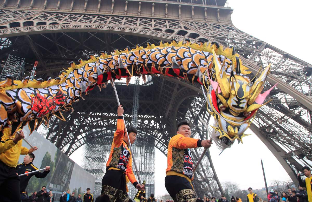 Members of the Chinese community dance with costumes to mark the Chinese New Year at the Eiffel Tower in Paris, Saturday Jan. 25, 2020. This year marks the “Year of the Rat” in the Chinese Lunar calendar.