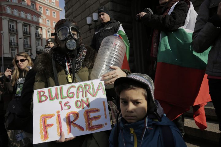 Bulgarian protester is wearing a gas mask and holds a poster and an empty water canister during a protest against the alleged mismanagement of Bulgarian government that led to a water crisis in Sofia, on Saturday, Jan.25, 2019.  Citizens have been protesting for weeks, holding authorities accountable for bringing their city to the verge of what they are calling a humanitarian crisis. 