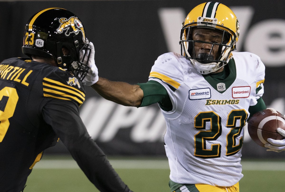 Edmonton Eskimos' Christion Jones (22) gets a hand into the face of Hamilton Tiger Cats' Nick Shortill (23) during second half CFL football game action in Hamilton, Ont., Friday, Oct. 4, 2019. The Edmonton Eskimos signed American returner Christion Jones to a contract extension Monday. 