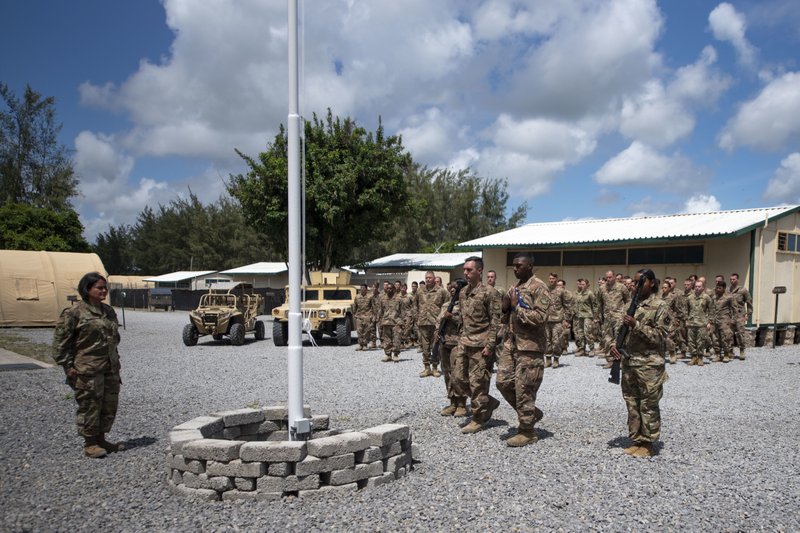 In this photo taken Aug. 26, 2019 and released by the U.S. Air Force, airmen from the 475th Expeditionary Air Base Squadron conduct a flag-raising ceremony, signifying the change from tactical to enduring operations, at Camp Simba, Manda Bay, Kenya. The al-Shabab extremist group said Sunday, Jan. 5, 2020 that it has attacked the Camp Simba military base used by U.S. and Kenyan troops in coastal Kenya, while Kenya's military says the attempted pre-dawn breach was repulsed and at least four attackers were killed.