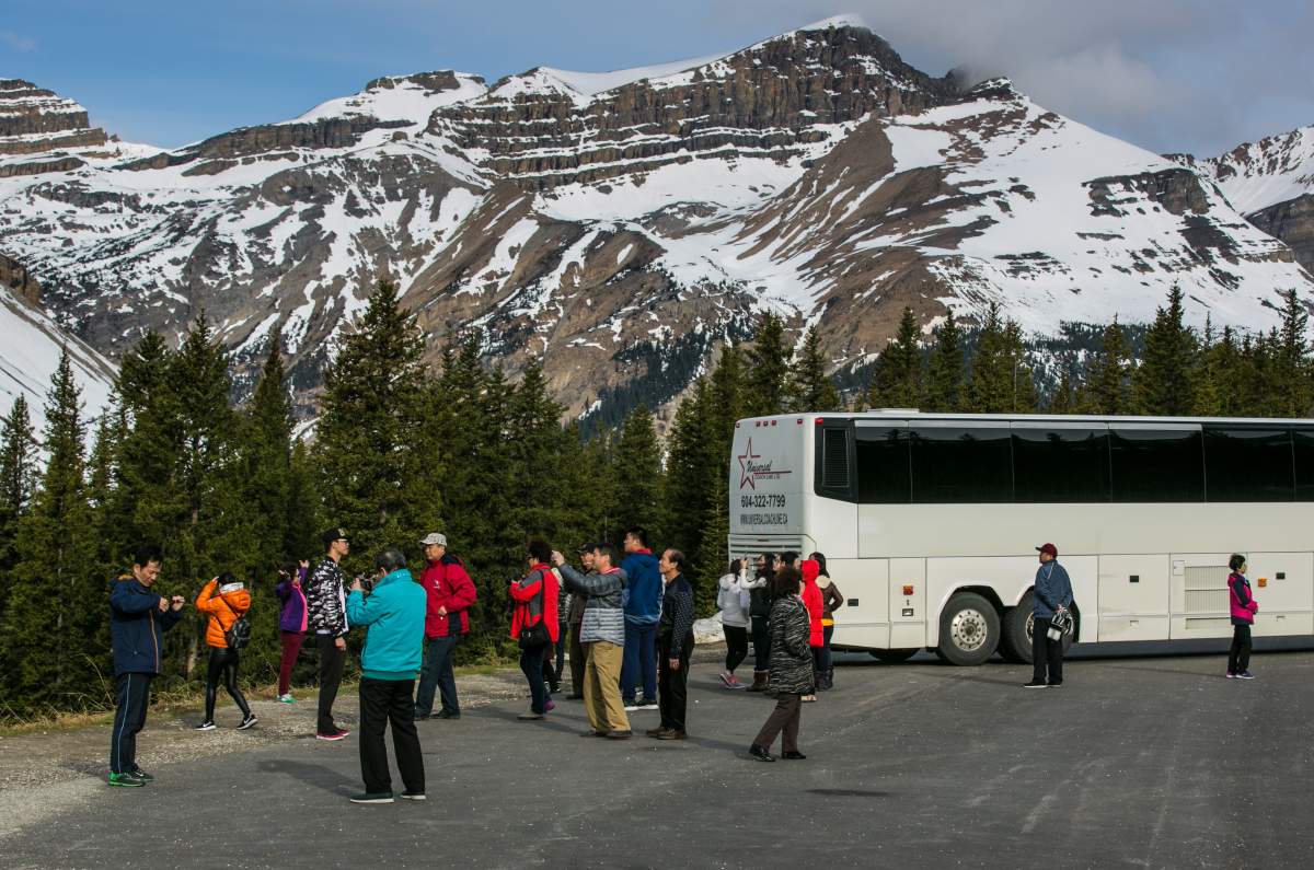 A group of tourists stop to take pictures of the Rockies along the Icefields Parkway between Lake Louise and Jasper on April 25, 2016 near Jasper, Alberta, Canada.