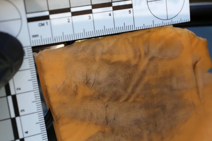 A slice of processed cheese is covered in fingerprinting dust in this image from Carrollton police.