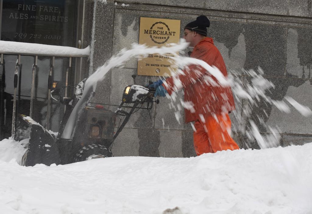 A man clears the sidewalk on Water Street in St. John's on Monday, January 6, 2020. An artist's imagining of St. John's, N.L.'s downtown streets as a ski hill map has resonated with winter-weary residents recovering from the year's first major winter storm.