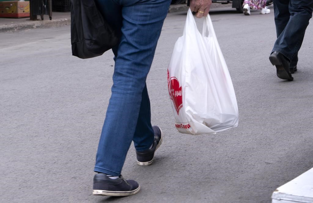 A woman carries a plastic bag at a market in Montreal on June 13, 2019.