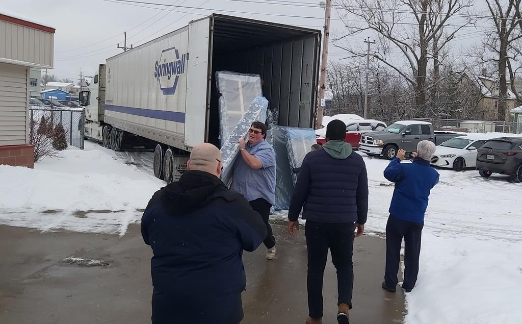 People unload mattress' and box springs in Sydney, N.S. in this undated handout photo.