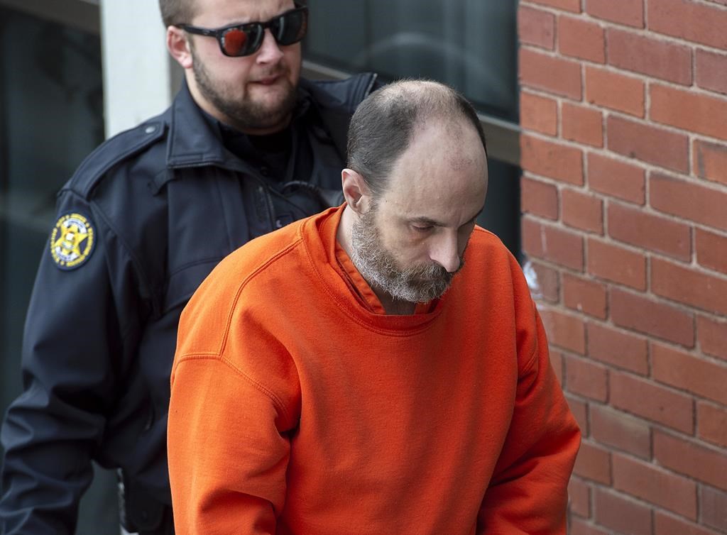 Matthew Vincent Raymond is escorted at Court of Queen's Bench in Fredericton on Wednesday, Dec. 18, 2019.
