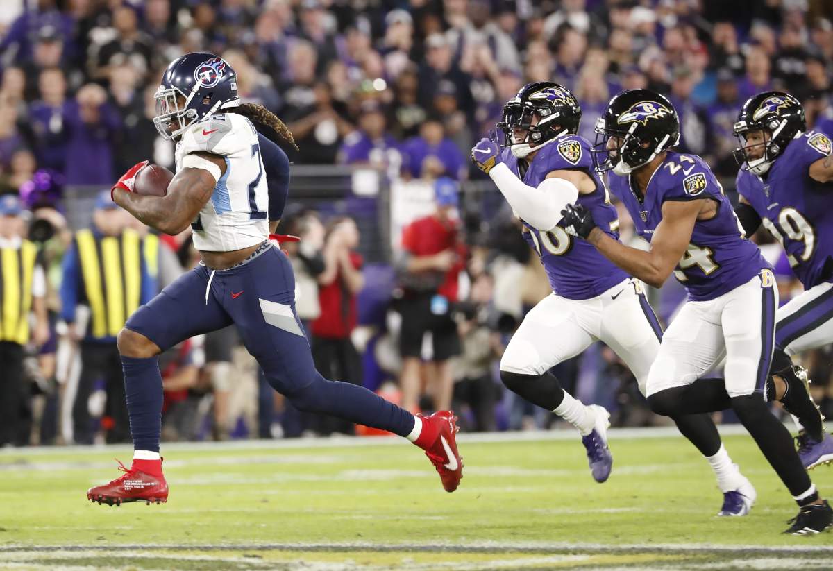Tennessee Titans running back Derrick Henry (L) runs for a 66-yard gain against the Baltimore Ravens in the third quarter of their NFL playoff game at M & T Bank Stadium in Baltimore, Maryland, on Jan. 11, 2020.