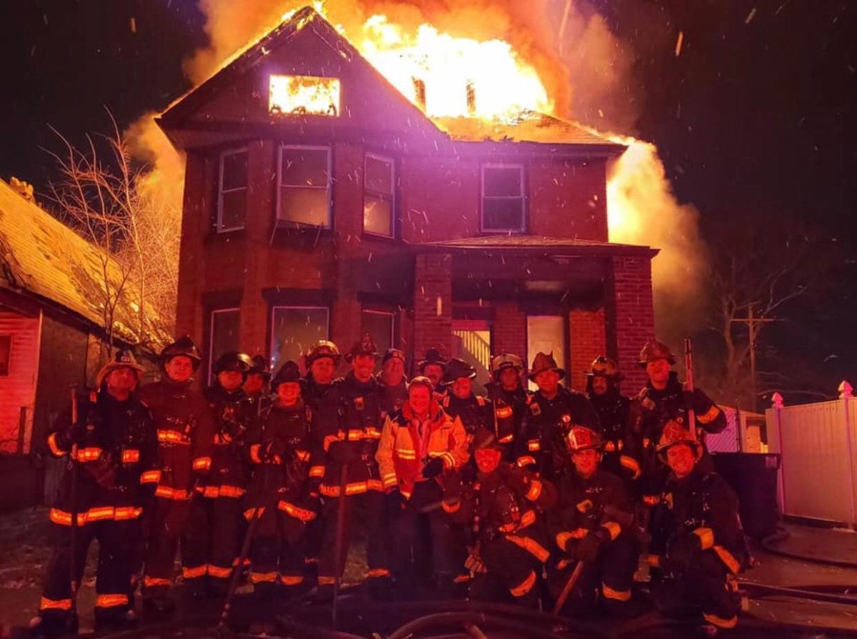 Firefighters in Detroit, Mich., pose in front of a burning house for a photo posted on Facebook Dec. 31, 2019.