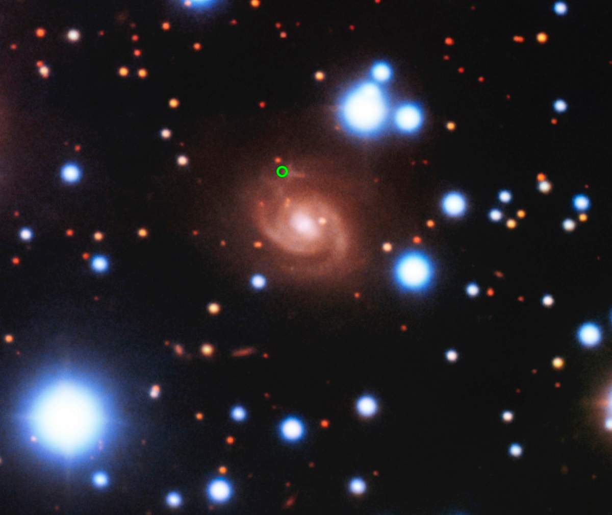 An image of the host galaxy of FRB 180916 (centre) acquired with the eight-metre Gemini-North telescope of NSF’s OIR Lab on Hawaii’s Maunakea. The origin point has been circled.