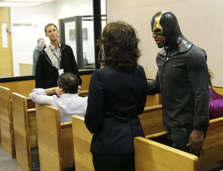 Ben Fodor, right, a self-styled superhero who goes by the name ‘Phoenix Jones,’ talks with one of his attorneys, Caitlin DiMotta, centre, as they appear in court on Oct. 13, 2011, in Seattle.