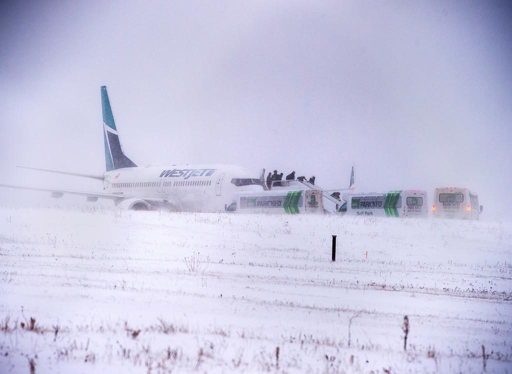Passengers disembark a Westjet aircraft that skidded off the runway at Halifax Stanfield International Airport on Sunday, Jan. 5, 2020.