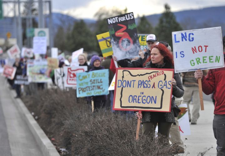 FILE – In this Jan. 6, 2016, file photo, people protest against the Jordan Cove LNG Pipeline on Crater Lake Highway in Medford, Ore. A Canadian energy company on Friday, Jan. 24, 2020, withdrew its application for a state permit for the project, and a project spokesman said it is instead awaiting possible federal approval. (Jamie Lusch/The Medford Mail Tribune via AP, File)